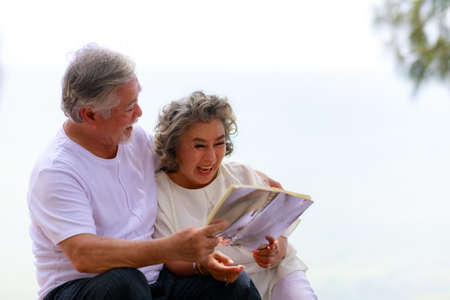 Happy elderly retirement  senior  couple have fun while reading a book together.の写真素材