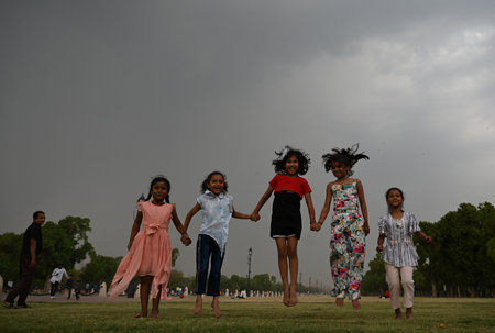 NEW DELHI, INDIA - APRIL 13: Children enjoy cloudy and raining weather at Kartavya Path, on April 13, 2024 in New Delhi, India. IMD said that due to the influence of several weather systems, including an intense western disturbance as a cyclonic circulatiのeditorial素材