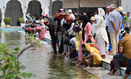 NEW DELHI, INDIA - APRIL 13: Devotees take a dip in the sacred pond of Gurudwara Bangla Sahib on the occasion of Baisakhi festival, on April 13, 2024 in New Delhi, India. Baisakhi or Vaisakhi, a popular spring festival that marks the first day of the montのeditorial素材