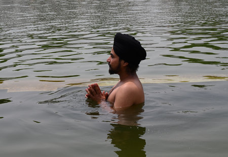 NEW DELHI, INDIA - APRIL 13: Devotees take a dip in the sacred pond of Gurudwara Bangla Sahib on the occasion of Baisakhi festival, on April 13, 2024 in New Delhi, India. Baisakhi or Vaisakhi, a popular spring festival that marks the first day of the montのeditorial素材
