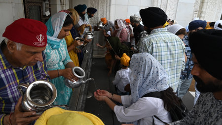 NEW DELHI, INDIA - APRIL 13: Devotees sip holy water after prayer at Gurudwara Bangla Sahib on the occasion of Baisakhi festival, on April 13, 2024 in New Delhi, India. Baisakhi or Vaisakhi, a popular spring festival that marks the first day of the month のeditorial素材