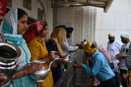 NEW DELHI, INDIA - APRIL 13: Devotees sip holy water after prayer at Gurudwara Bangla Sahib on the occasion of Baisakhi festival, on April 13, 2024 in New Delhi, India. Baisakhi or Vaisakhi, a popular spring festival that marks the first day of the month のeditorial素材
