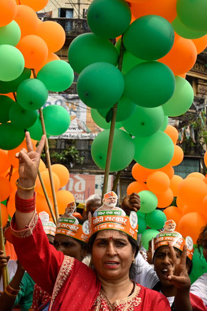 KOLKATA, INDIA - MAY 10: Bharatiya Janata Party (BJP) supporters wearing a hat of Narendra Modi face and flags during nomination filing rally by Kolkata Dakshin Lok Sabha Constituency BJP Candidate Debasree Chaudhuri at Hazra crossing on May 10, 2024 in Kのeditorial素材