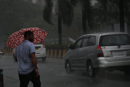 NAVI MUMBAI, INDIA - MAY 13: People wade through unseasonal rains at Vashi area on May 13, 2024 in...