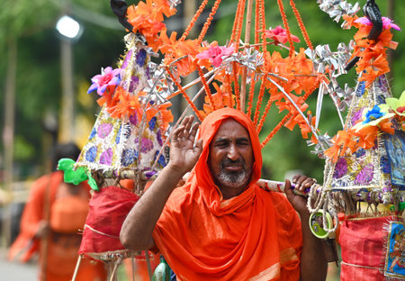 NOIDA, INDIA - JULY 27: After the rain in Delhi-NCR, the temperature has increased and the devotees kavadiya are covering their heads to save themselves from the humid heat, on July 27, 2024 in Noida, India. (Photo by Sunil Ghosh/Hindustan Times )のeditorial素材