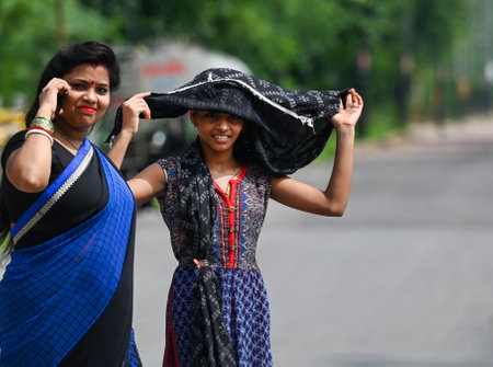 NOIDA, INDIA - JULY 27: As the temperature in Delhi-NCR rises after the rain, commuters in Sector 14 are covering their heads to avoid the heat, on July 27, 2024 in Noida, India. (Photo by Sunil Ghosh/Hindustan Times )のeditorial素材