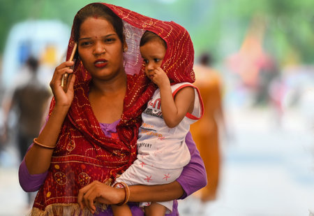 NOIDA, INDIA - JULY 27: As the temperature in Delhi-NCR rises after the rain, commuters in Sector 14 are covering their heads to avoid the heat, on July 27, 2024 in Noida, India. (Photo by Sunil Ghosh/Hindustan Times )のeditorial素材