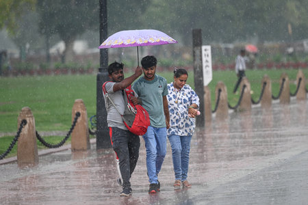 NEW DELHI, INDIA - JULY 27: People seen during sudden rains at India Gate, on July 27, 2024 in New...