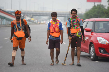 GURUGRAM, INDIA - JULY 27: Kanwariyas carrying holy water collected from River Ganga in Haridwar going back to their hometown in Rajasthan state during the Kanwar Yatra at National Highway-48 near Signature Towre Chowk, on July 27, 2024 in Gurugram, Indiaのeditorial素材