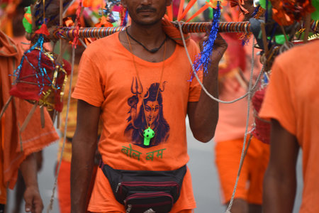GURUGRAM, INDIA - JULY 27: Kanwariyas carrying holy water collected from River Ganga in Haridwar going back to their hometown in Rajasthan state during the Kanwar Yatra at National Highway-48 near Signature Towre Chowk, on July 27, 2024 in Gurugram, Indiaのeditorial素材