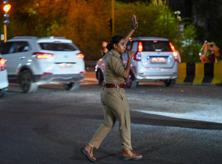 NOIDA, INDIA - JULY 29: A woman Noida police personnel helping Kanwariyas to cross the road at Noida-Delhi Chilla border on Sunday night,  on July 29, 2024 in Noida, India.  (Photo by Sunil Ghosh/Hindustan Times)のeditorial素材