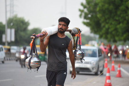 GURUGRAM, INDIA - JULY 30:  Kanwariyas carrying holy water in collected from River Ganga in Haridwar going back to their hometown in Gurugram District during the Kanwar Yatra at National Highway-48 near Rajiv chowk on July 30, 2024  in Gurugram, India. (Pのeditorial素材