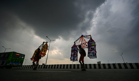 NEW DELHI, INDIA - JULY 31: Kanwariyas carry holy water collected from Ganga River in Haridwar under the Black Clouds during Kanwar Yatra near Akshardham Crossing  on July 31, 2024  in New Delhi, India.  (Photo by Raj K Raj/Hindustan Times)のeditorial素材