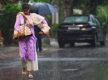 NOIDA, INDIA - JULY 30: Commuters stepping out during the evening rain after a humid summer, on July 30, 2024 in Noida, India. (Photo by Sunil Ghosh/Hindustan Times )のeditorial素材