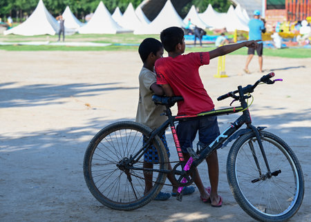 NOIDA, INDIA - AUGUST 4: Kids riding bicycle with their friend on Happy Friendship Day. Friendship Day, celebrated on the first Sunday of August each year, is a joyous occasion to honor and cherish the beautiful bonds of friendship that enrich our lives, のeditorial素材