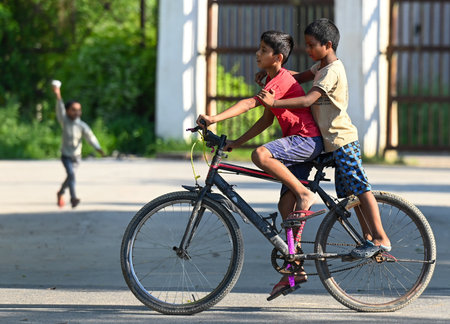NOIDA, INDIA - AUGUST 4: Kids riding bicycle with their friend on Happy Friendship Day. Friendship Day, celebrated on the first Sunday of August each year, is a joyous occasion to honor and cherish the beautiful bonds of friendship that enrich our lives, のeditorial素材