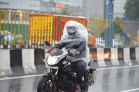 GURUGRAM, INDIA - AUGUST 11: Commuters going to their work amid heavy rain at Badshahpur road near...