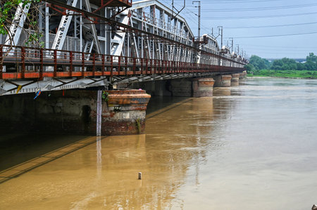 NEW DELHI, INDIA - AUGUST 14: Flooded Yamuna River seen flows under the Iron Bridge in the afternoon  on August 14, 2024 in New Delhi, India. The water level of the river has touched 204.35 metre at the Old Railway Bridge (ORB). The warning level is at 20のeditorial素材