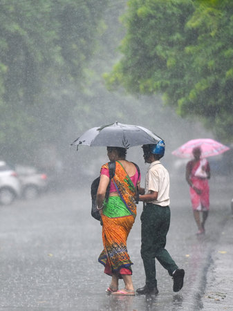 NOIDA, INDIA - AUGUST 23: Commuters step out during rain at sector 12, on August 23, 2024 in Noida,...
