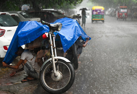 NOIDA, INDIA - SEPTEMBER 5 2024  Commuters step out during afternoon rain at sector 12, on Delhi-NCR...
