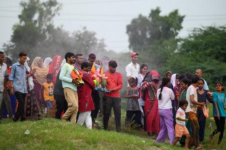 NOIDA INDIA SEPTEMBER 11 2024 Devotees gather at the Yamuna River during the immersion ceremony on...