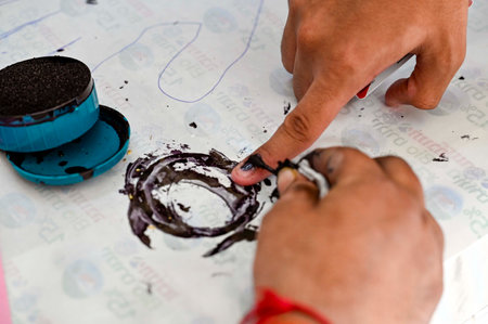NEW DELHI, INDIA - SEPTEMBER 27: A polling officer puts an indelible ink mark on the index finger of one of the Student cast their votes during the Delhi University Students Union (DUSU) polls 2024, at Hindu college on September 27, 2024 in New Delhi, Indのeditorial素材