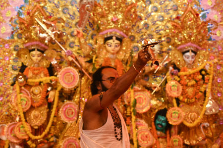 GURUGRAM, INDIA - OCTOBER 10: A Hindu Purohit offers prayer to Goddess Durga during the Durga Puja...