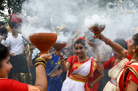 KOLKATA, INDIA - OCTOBER 13: Women in traditional dress perform dhunuchi dance during immersion of idols of Goddess Durga on the tenth day of Durga Puja Festival at Baje Kadamtala Ghat on the banks of river Hooghly on October 13, 2024 in Kolkata, India. (のeditorial素材