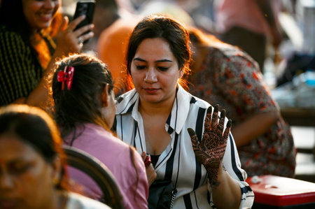 NEW DELHI, INDIA - OCTOBER 19: A woman gets her hands colored with mehendi at Hanuman Temple in...