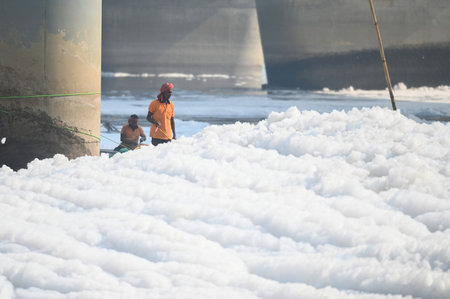 NEW DELHI INDIA OCTOBER 29 2024 Delhi authorities workers spray defoamer chemicals to dissolve the toxic foam at the Yamuna River at Kalindi Kunj on October 29 2024 in New Delhi India The pungent foam contains high levels of ammonia and phosphates posing のeditorial素材