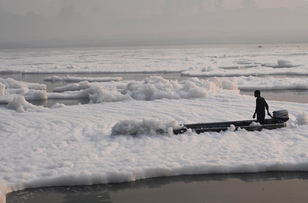 NEW DELHI, INDIA - NOVEMBER 3: Workers from the district Administration spraying chemicals to dissolve the toxic foam over Yamuna River at Kalindi Kunj, on November 3, 2024 in New Delhi, India. The Yamuna River is inundated with toxic foam ahead of Chhathのeditorial素材