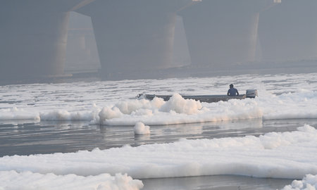 NEW DELHI, INDIA - NOVEMBER 3: Workers from the district Administration spraying chemicals to dissolve the toxic foam over Yamuna River at Kalindi Kunj, on November 3, 2024 in New Delhi, India. The Yamuna River is inundated with toxic foam ahead of Chhathのeditorial素材