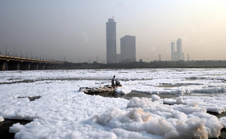 NEW DELHI, INDIA - NOVEMBER 2: Delhi authorities workers moving their boats to settle the toxic form at the Yamuna River at Kalindi Kun on November 2, 2024 in New Delhi, India. The Yamuna River is inundated with toxic foam ahead of Chhath Puja, set to be のeditorial素材