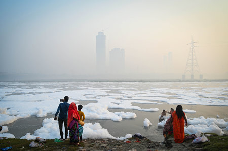 NEW DELHI INDIA NOVEMBER 5 2024 Devotees perform pre Chhath Puja rituals as toxic foam floats on the surface of the Yamuna River at Kalindi Kunj on November 5 2024 in New Delhi India Photo by Sanchit Khanna Hindustan Timesのeditorial素材