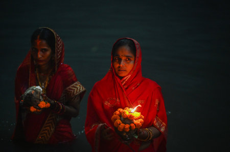 NOIDA INDIA NOVEMBER 8 2024 Devotees performing the rituals of offering Arghya to the rising sun in the Yamuna River on the fourth and last day of Chhath Puja A festival dedicated to Lord Surya Chhath Puja is celebrated with rich rituals over four days Roのeditorial素材