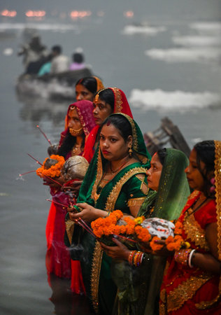 NOIDA INDIA NOVEMBER 8 2024 Devotees performing the rituals of offering Arghya to the rising sun in the Yamuna River on the fourth and last day of Chhath Puja A festival dedicated to Lord Surya Chhath Puja is celebrated with rich rituals over four days Roのeditorial素材
