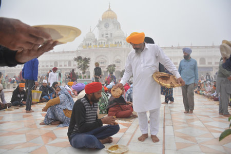 AMRITSAR, INDIA - NOVEMBER 15: Devotees partaking of langar on the occasion of birth anniversary of...