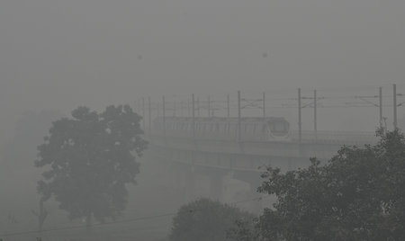 NEW DELHI, INDIA - NOVEMBER 18:  A metro train moves along tracks near the Akshardham Temple area,...