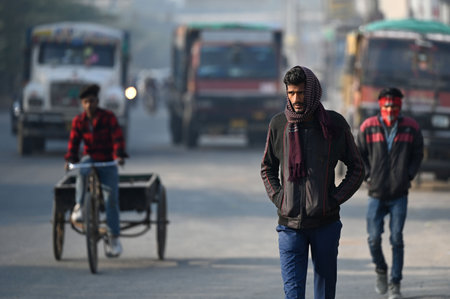 NEW DELHI, INDIA - DECEMBER 15: People are seen wearing warm clothes to protect themselves amid cold morning, at Shaheen Bagh, on December 15, 2024 in New Delhi, India. According to the weather office, the minimum temperature is likely to hover around 6 aのeditorial素材