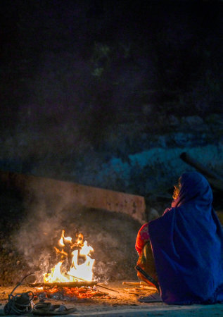 NOIDA, INDIA - DECEMBER 15: People seen sitting around bonfires to escape the cold on December 15, 2024 in Noida, India. According to the weather office, the minimum temperature is likely to hover around 6 and 7 degrees throughout the week with chances ofのeditorial素材