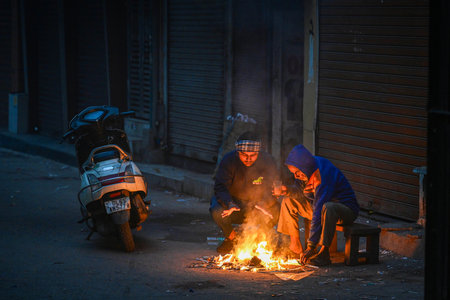 NEW DELHI INDIA DECEMBER 17 2024 People sitting near a bornfire during a cold morning at Karol Bagh on December 17 2024 in New Delhi India Delhi NCR witnessed severe smog and drastically reduced visibility on morning as air quality plummeted back into theのeditorial素材