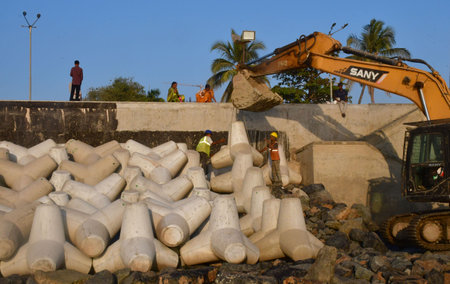 MUMBAI INDIA DECEMBER 17 2024 Workers install new tetrapods near the Coastal Road project at Marine...