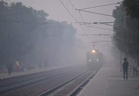 NEW DELHI INDIA DECEMBER 22 2024 Passengers Train Moves in early morning winter fog near Dwarka on December 22 2024 in New Delhi India Delhi NCR experienced a foggy morning on Sunday with the minimum temperature recorded at 7 3 degrees Celcius two notchesのeditorial素材