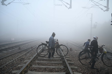 GURUGRAM, INDIA - DECEMBER 25: People are seen wearing warm clothes amid cold and dense foggy weather at Gurugram Railway Station near Rajendra Park, on December 25, 2024 in Gurugram, India. A cold wave has hit India, leaving several states grappling withのeditorial素材