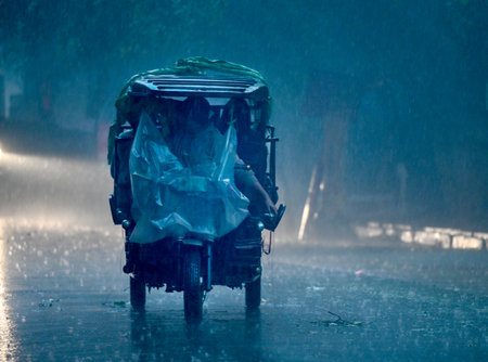 NOIDA, INDIA - DECEMBER 27: Commuters during winter rain in Sector 12, rain adds to severe cold wave in North India Several parts of Delhi-NCR received rainfall in the morning, on December 27, 2024 in Noida, India. Delhi and nearby areas received moderateのeditorial素材