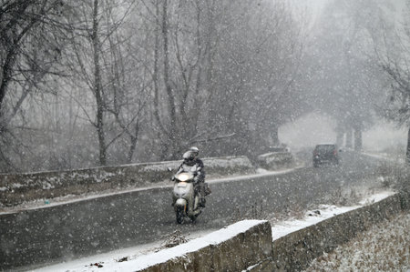 SRINAGAR, INDIA - DECEMBER 27: Vehicles ply during the first snowfall of the season on December 27, 2024 in Srinagar, India. Minimum temperatures decreased at most places in Kashmir as the valley continued to reel under intense cold conditions, leading toのeditorial素材