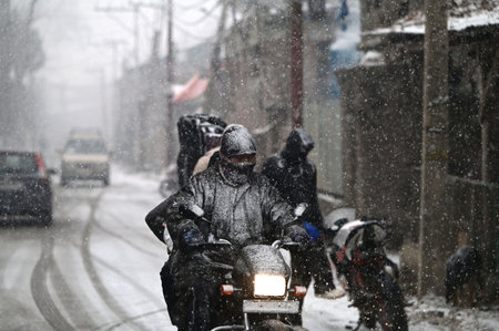 SRINAGAR, INDIA - DECEMBER 27: Vehicles ply during the first snowfall of the season on December 27, 2024 in Srinagar, India. Minimum temperatures decreased at most places in Kashmir as the valley continued to reel under intense cold conditions, leading toのeditorial素材