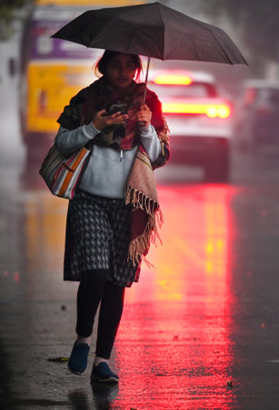 NOIDA, INDIA - DECEMBER 27: Commuters during winter rain in Sector 12, rain adds to severe cold wave in North India Several parts of Delhi-NCR received rainfall in the morning, on December 27, 2024 in Noida, India. Delhi and nearby areas received moderateのeditorial素材