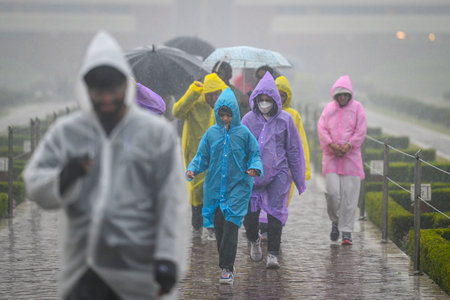 NEW DELHI, INDIA - DECEMBER 27: Tourists seen during heavy rainfall at Lotus Temple near Kalkaji, on...