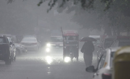 NEW DELHI, INDIA - DECEMBER 27: Commuters seen out in rain on a cold winter evening at Jangpura on...